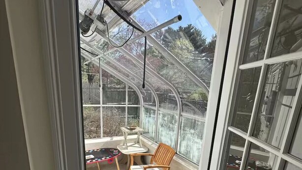 Ein Wintergarten mit Tisch, Stühlen und einer kleinen Spielecke.