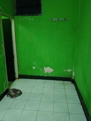 A room with green walls, a tiled floor, and a visible door leading to another room. - Hotel Paradiso Mataram (Mataram)