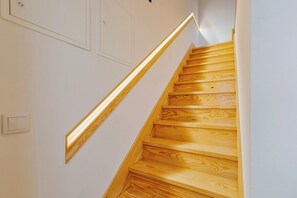 A wooden staircase with a light fixture on the wall. - Casa do Bocage, By Home Match (Setúbal)