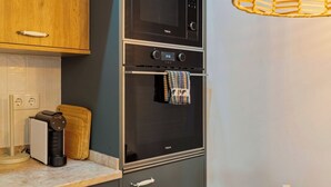 A kitchen with a microwave, oven, and coffee maker. - Casa do Bocage, By Home Match (Setúbal)