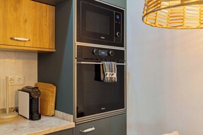 Eine Küche mit Mikrowelle, Backofen und Kaffeemaschine.