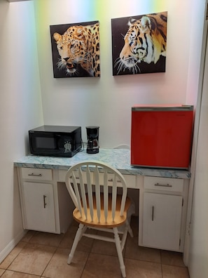 A small kitchenette with a microwave, coffee maker, and red refrigerator. - Soothing 1-bedroom house with AC in vibrant Orlando (Orlando)
