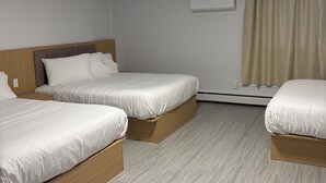 Ein Hotelzimmer mit drei Betten, einer Deckenleuchte, einer Klimaanlage und einem Fenster mit Vorhängen.