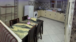 Eine moderne Küche mit Essbereich, mit gewölbter Decke und blauer Beleuchtung, einer Waschmaschine und einer Mikrowelle.