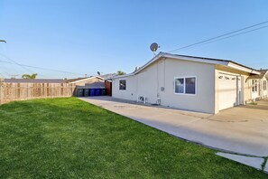 A single-story house with a garage, a small attached shed, and a well-maintained lawn. - Gated Yard, King Bed, 2 Living Rooms, Ranch Style (Spring Valley)
