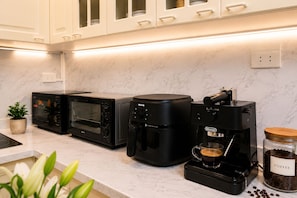Eine Küche mit Kaffeemaschine, Toasterofen und Kaffeemühle.