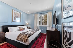A bedroom with a bed, a nightstand, a dresser, a window with curtains, and a framed picture on the wall. - New Designer Condo-King Bed, Pool/HT, Spa, Lake (Keystone)