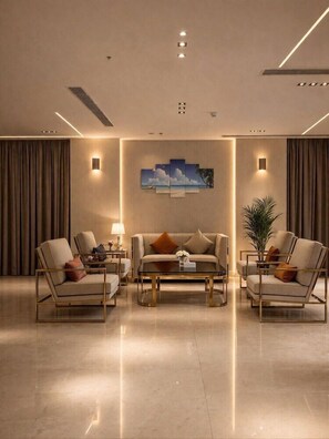 A modern hotel lobby with a sofa set, armchairs, a coffee table, and a large painting on the wall. - AL Shahba AL Faiha Hotel (Jeddah)