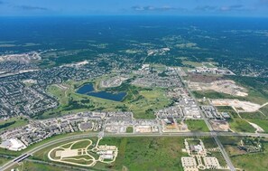An aerial view of a city with a large airport, residential areas, and green spaces. - Cozy 1-bedroom apartment with AC in serene location! (Kyle)