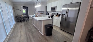 A modern kitchen with white cabinets, stainless steel appliances, and a central island. - Sunset Cove - Serene Lake Hartwell Lakefront Escape (Fair Play)