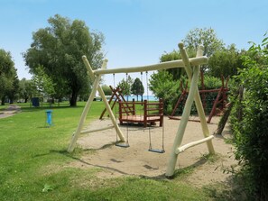 Ein Spielplatz mit Schaukeln und Klettergerüsten.