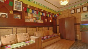 A wooden sofa with cushions, a wall with framed certificates, and a sign indicating a hotel. - Hotel Lekali Homes  (Kathmandu)