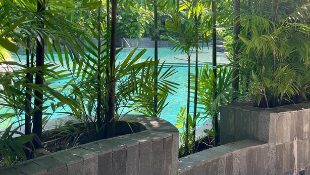 A pool surrounded by lush greenery and stone walls. - Oakwood Lavaya Nusa Dua Bali (Benoa)