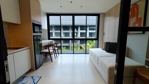 Eine moderne Wohnung mit Küche, Essbereich und einem großen Fenster mit Blick auf Gebäude und Grünflächen.