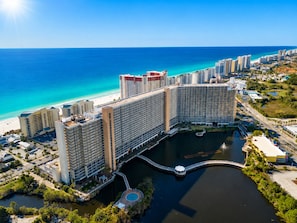 Ein großer Hotelkomplex mit mehreren Hochhäusern, einer Marina und einem Strand.