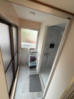 A compact bathroom with a shower, a towel rack, and a small window. - Within walking distance of Shibuya, Harajuku and Shinjuku! 86 sqm spacious family size apartment with balcony (渋谷区)