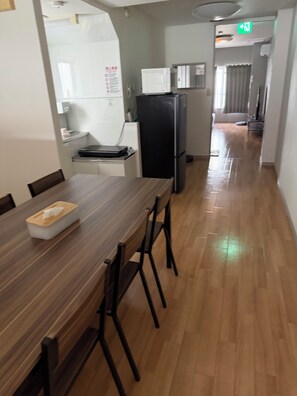 A dining area with a wooden table and chairs, a refrigerator, a microwave, and a kitchen counter. - Within walking distance of Shibuya, Harajuku and Shinjuku! 86 sqm spacious family size apartment with balcony (渋谷区)