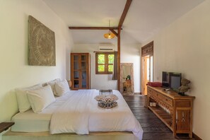 Ein Schlafzimmer mit einem Bett, einem Holzschrank und einem Fernseher.