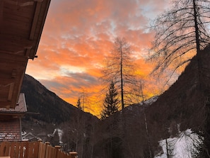 A wooden cabin with a view of a forested valley and a sunset. - Chalet Auszeit by Interhome (Flattach)
