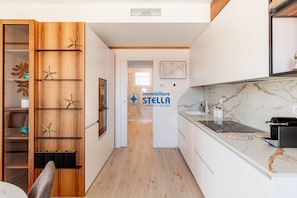 Eine moderne Küche mit Holzschrank, Marmorarbeitsplatte und dem Logo von 'immobiliare STELLA'.