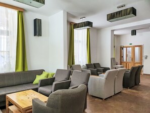 Ein stilvoller Loungebereich mit Sofas, Sesseln und einem Holztisch.