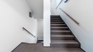 A modern staircase with a handrail, a white wall, and a ceiling with a skylight. - Janský Potok I. by Interhome (Janské Lázně)
