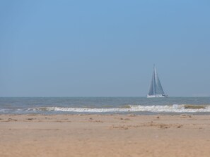 Ein Segelboot auf ruhiger See unter blauem Himmel.