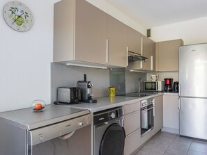 Een moderne keuken met een Bosch vaatwasser, een koffiezetapparaat, een magnetron en een koelkast.
