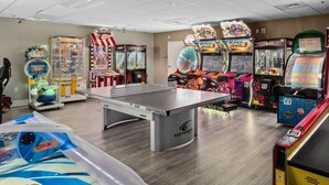 Quarto com mesa de pingue-pongue, jogos eletrônicos e mesa de bilhar.