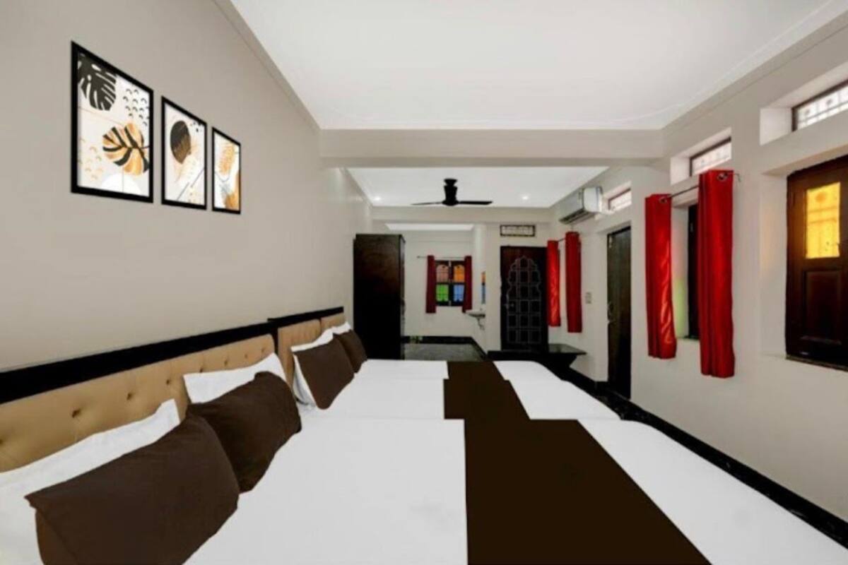 Une chambre d’hôtel avec un grand lit, une tête de lit et un ventilateur de plafond.
