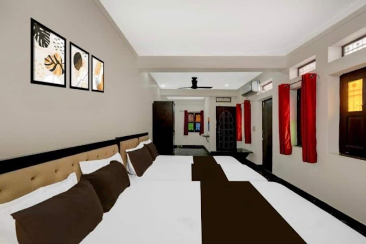 A hotel room with a large bed, a headboard, and a ceiling fan.