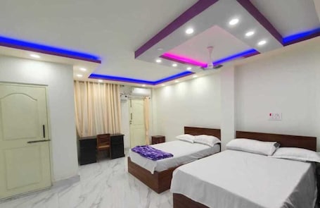 A hotel room with two beds, a wardrobe, a ceiling fan, and recessed lighting.. Hotel Tene & Resort