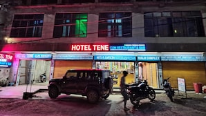 En byggnad med en skylt som visar texten ”HOTEL TENE, RESTAURANG & BAR” och en parkerad SUV.