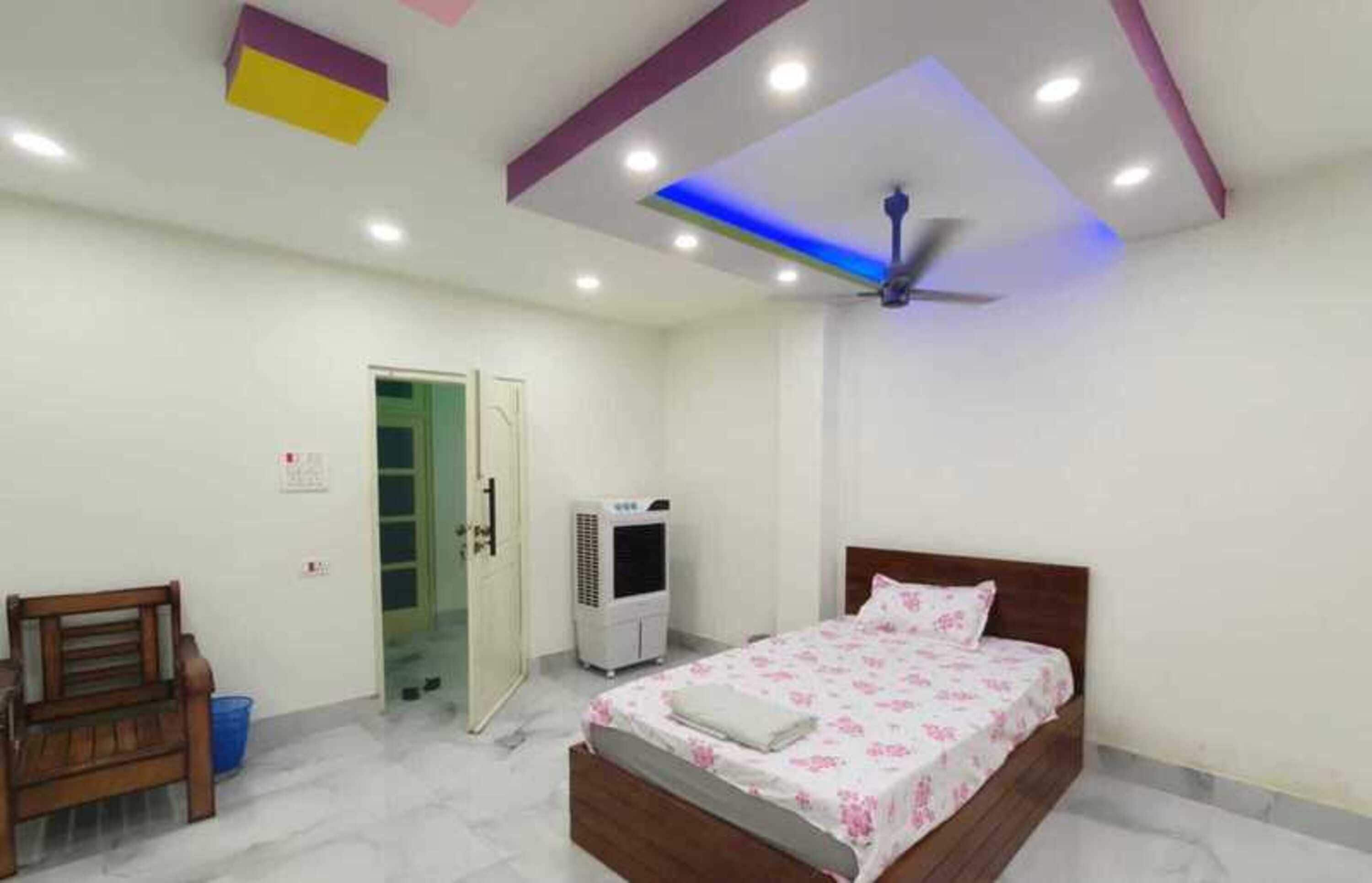 A bedroom with a bed, a ceiling fan, an air conditioner, and a bench.