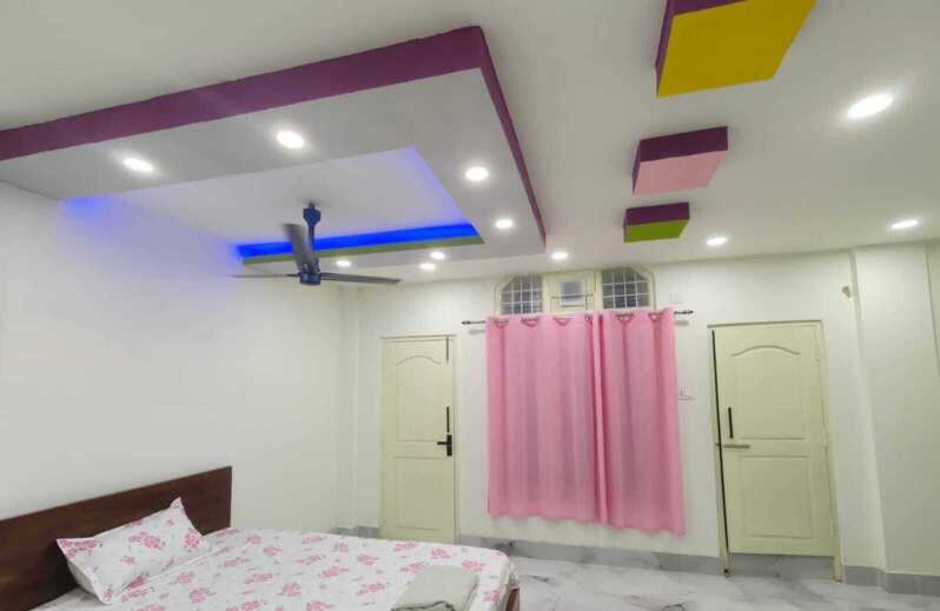A bedroom with a bed, a ceiling fan, and two doors.