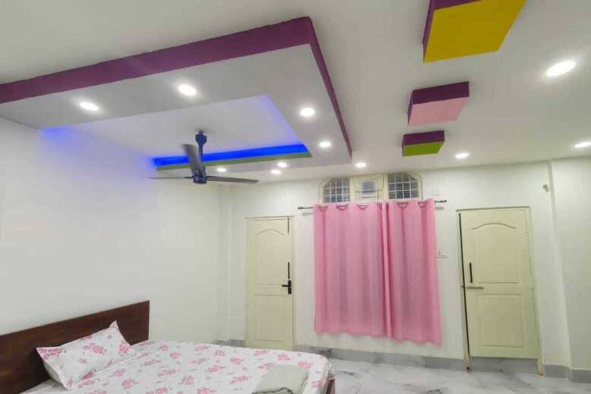 A bedroom with a bed, a ceiling fan, and two doors.
