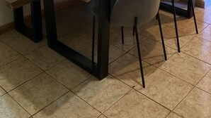Ein Essbereich mit einem Holztisch, vier Stühlen, einer Bank und einem Bild an der Wand.