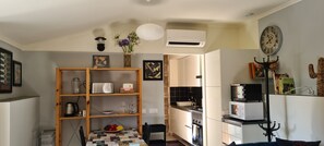 A kitchen with a wooden shelf, a clock, and a white air conditioner. - Fully equipped rental, close to everything. Quiet (Obidos)