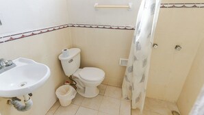Une salle de bain avec des toilettes, un lavabo et un rideau de douche.