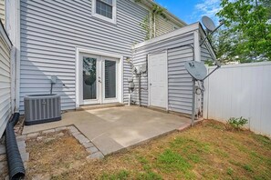 A residential backyard with a concrete patio, a satellite dish, and an air conditioning unit. - Nurses & Military Stays Near Ft Campbell + Vanderbilt Health + APSU (Clarksville)