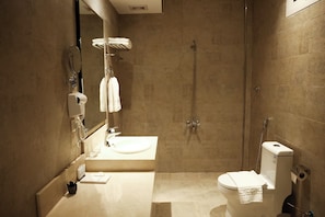 Une salle de bain moderne Ă©quipĂ©e dâune douche, dâun lavabo, de toilettes et dâun porte-serviettes.