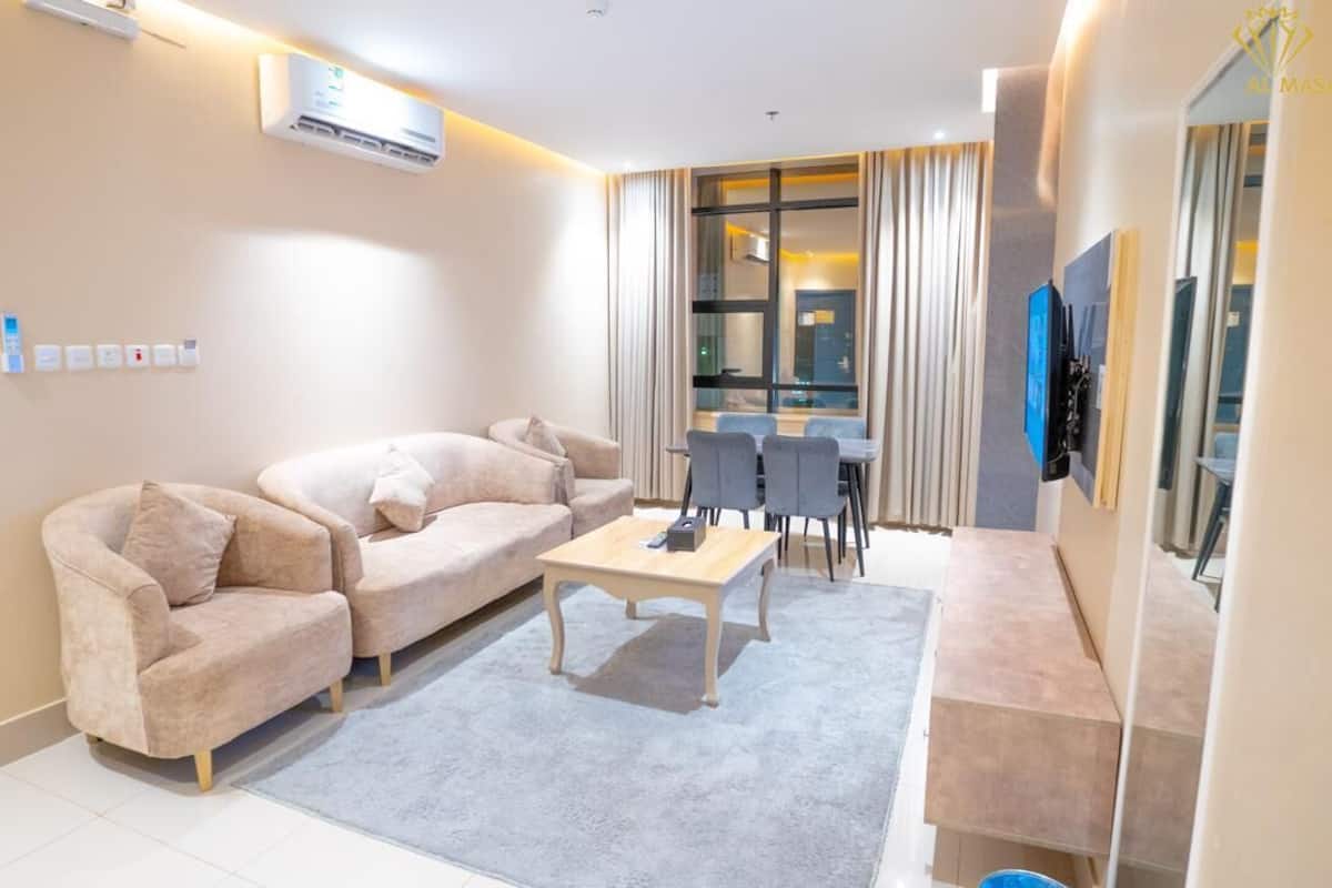 Uma sala de estar moderna com um conjunto de sofás, uma mesa de centro e um espaço de jantar com cadeiras.