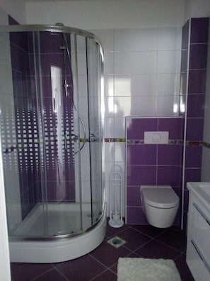 A bathroom with a glass-enclosed shower, a toilet, and a sink. - Villa Duje Old town (Trogir)