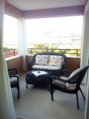 A balcony with a sofa, two chairs, and a small table. - Villa Duje Old town (Trogir)