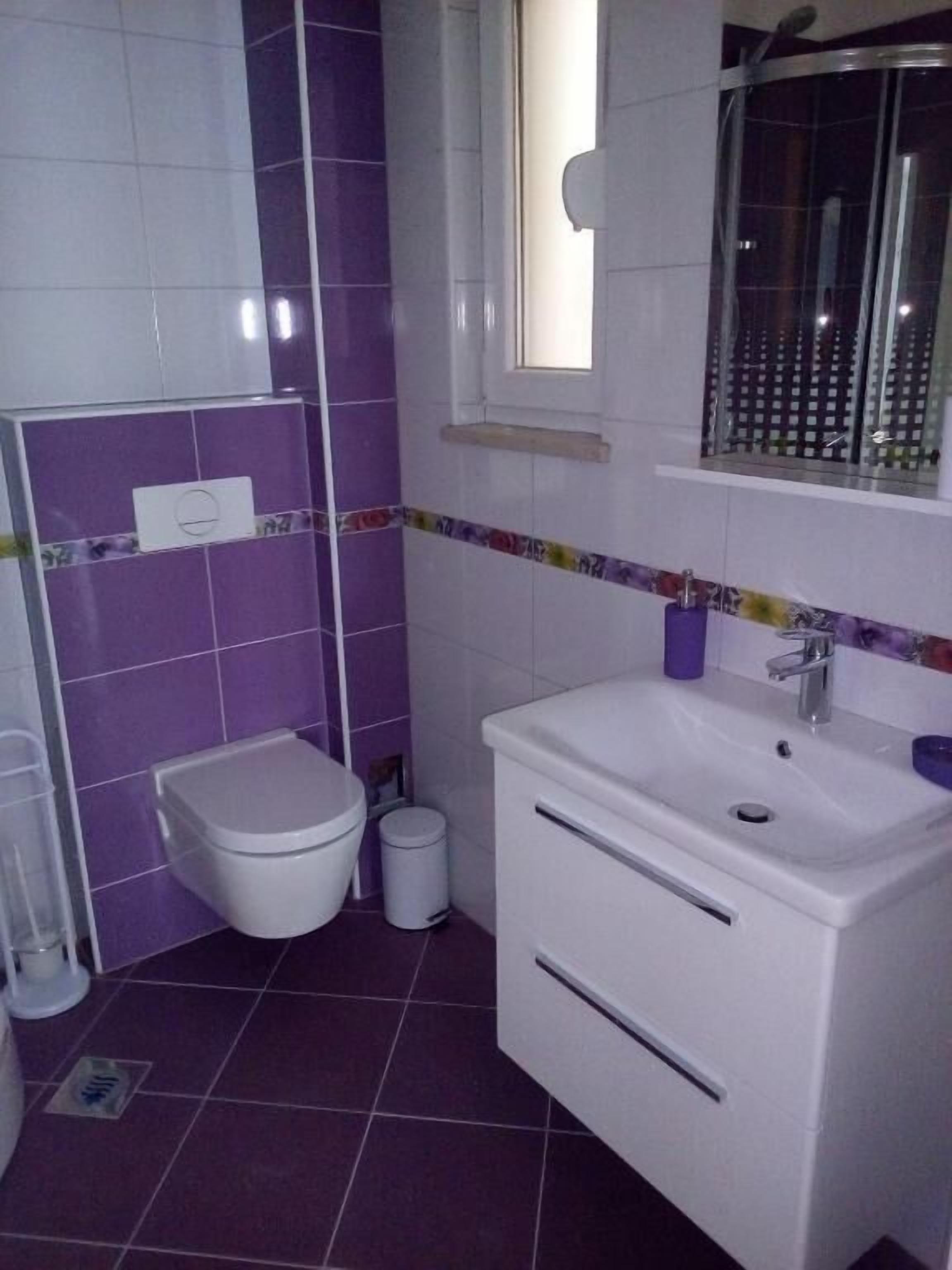 Un baño con inodoro, bidé, lavabo y espejo.