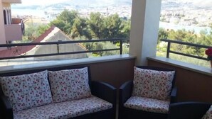 Ein Balkon mit einer Sofagarnitur und einem Tisch mit einer Snackschale und zwei Tassen.