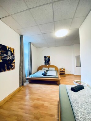 A bedroom with a wooden bed, a small bedside table, and a wall-mounted shelf. - Private Room Long Stay Near Station (Wien)