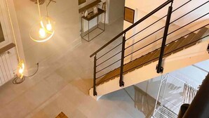 A staircase with a black railing, a white curtain, and a framed artwork on the wall. - Nice Old Town 3BR Duplex - AC, Easy Check-in, Cathedral Area (Nice)