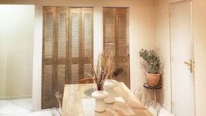 A dining area with a wooden table, chairs, and a hanging light fixture. - Nice Old Town 3BR Duplex - AC, Easy Check-in, Cathedral Area (Nice)
