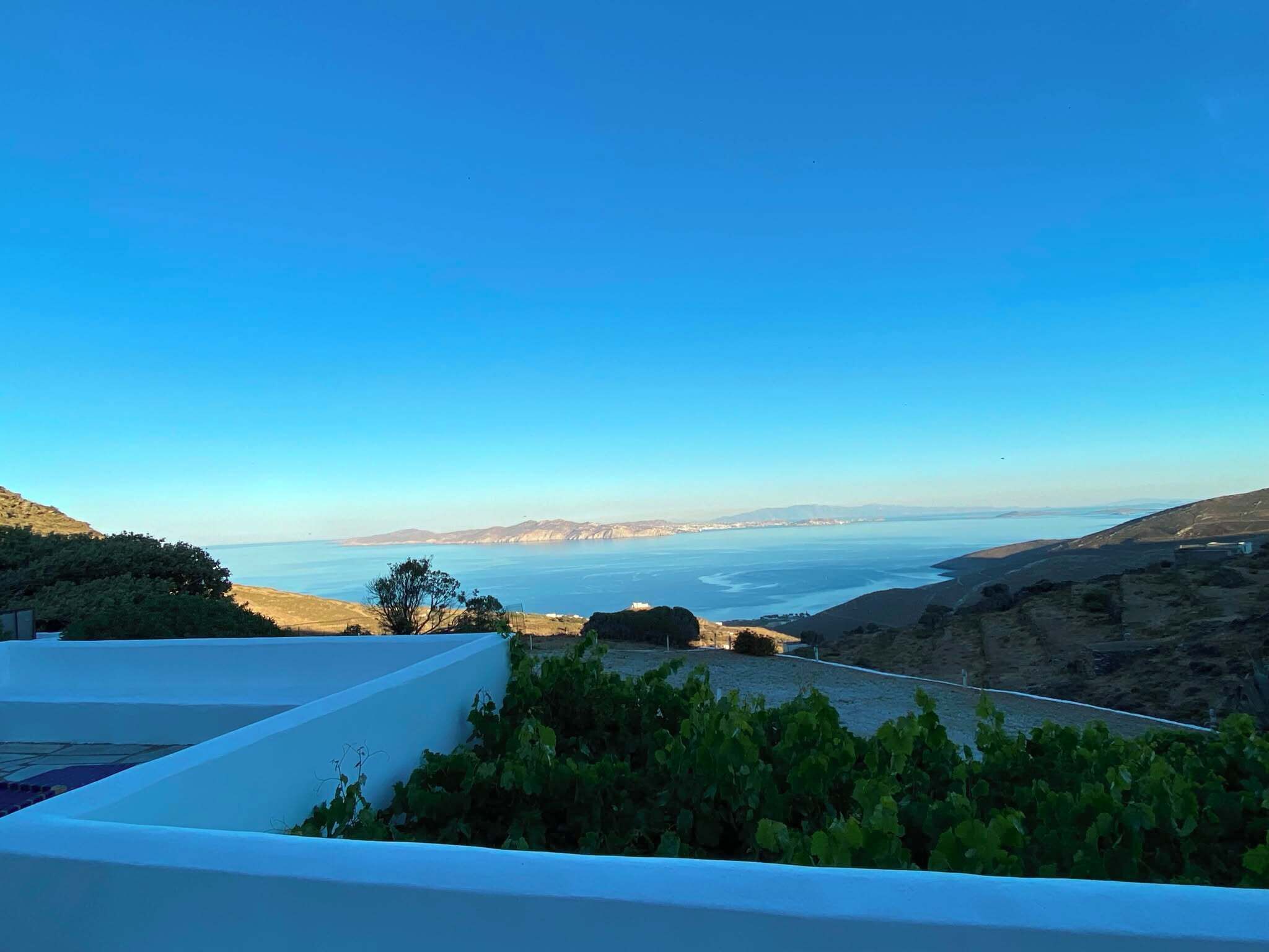 A terrace with a view of the sea and distant mountains.